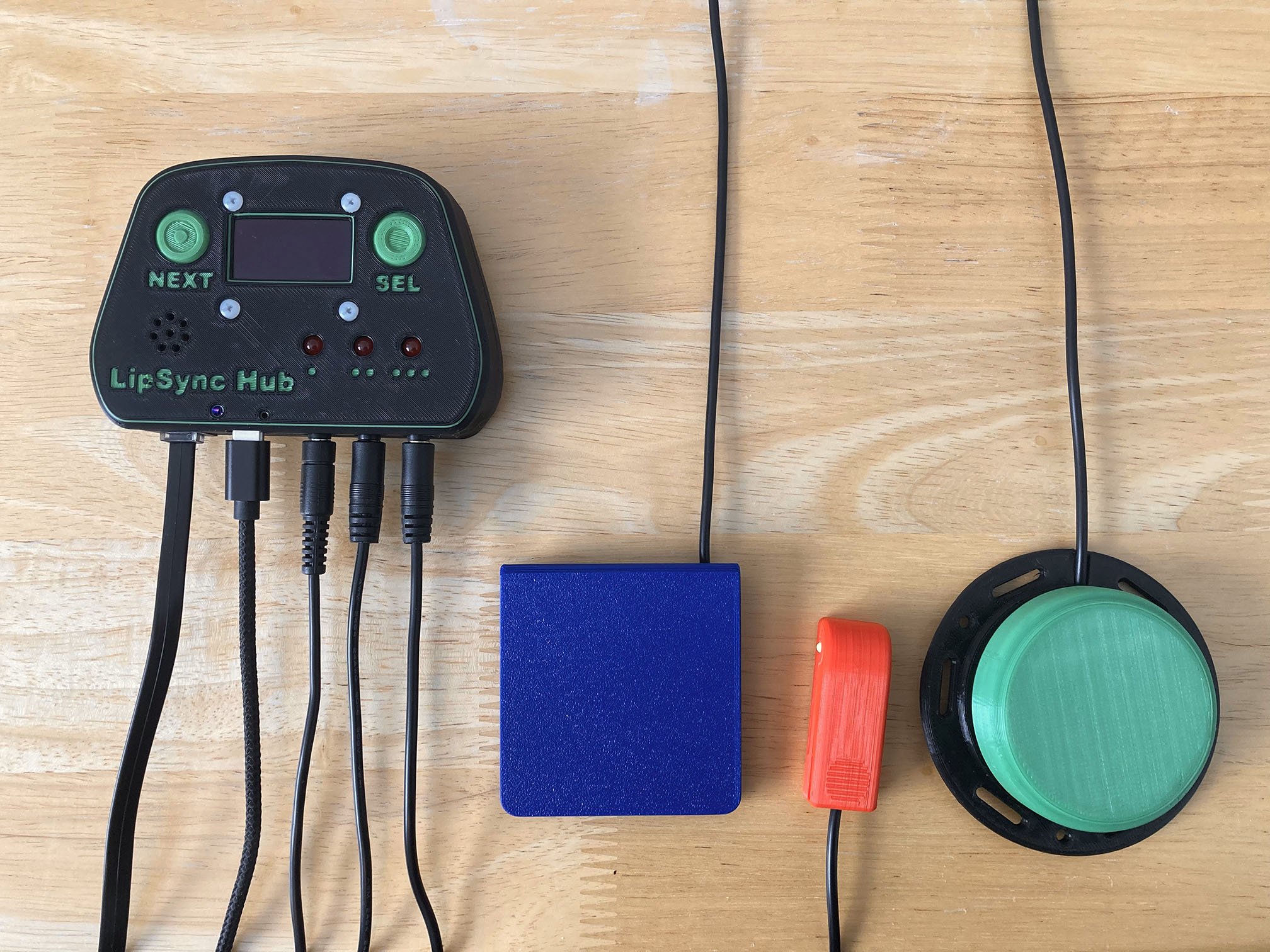 A green 3D printed LipSync Hub with three switches
