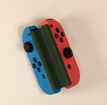 Blue and red Nintendo Switch joy-cons connected together by a green 3D printed controller adaptation
