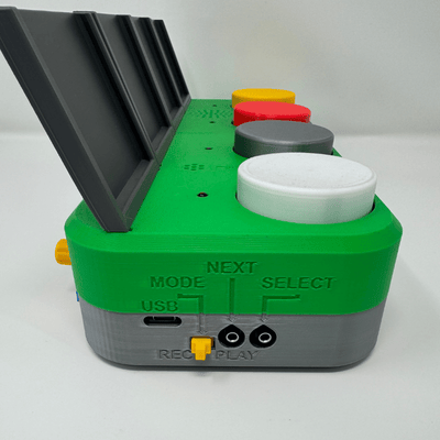 Labels on the side of the Chatterbox. There is a hole labeled "USB" for the USB cable, the mode switch with "REC" and "PLAY" to indicate the modes, and the "NEXT" and "SELECT" labels for the assistive switch jacks.
