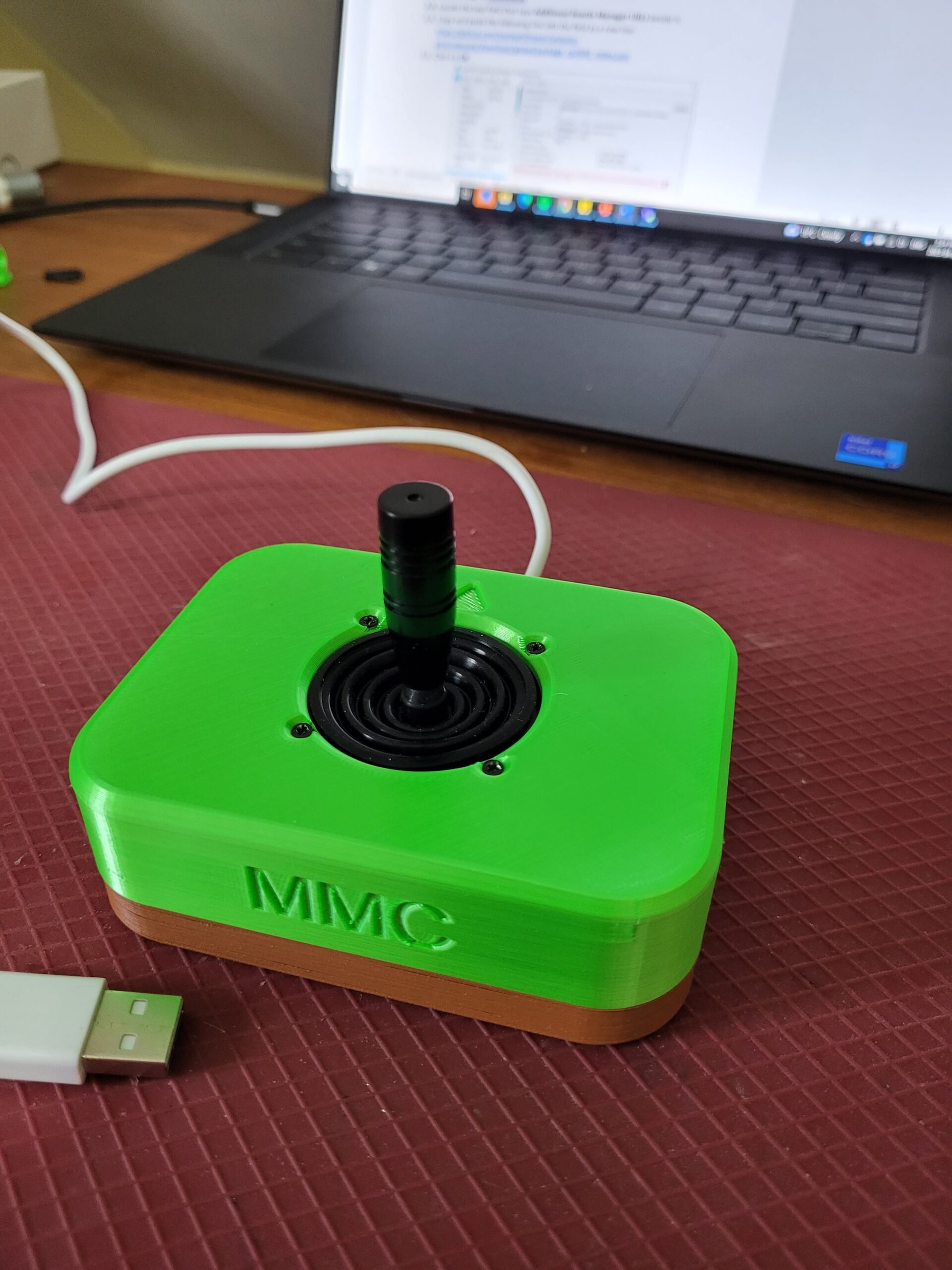 A green 3d printed "Oak" joystick connected to a laptop
