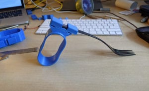 An assistive device for supporting utensils in blue.