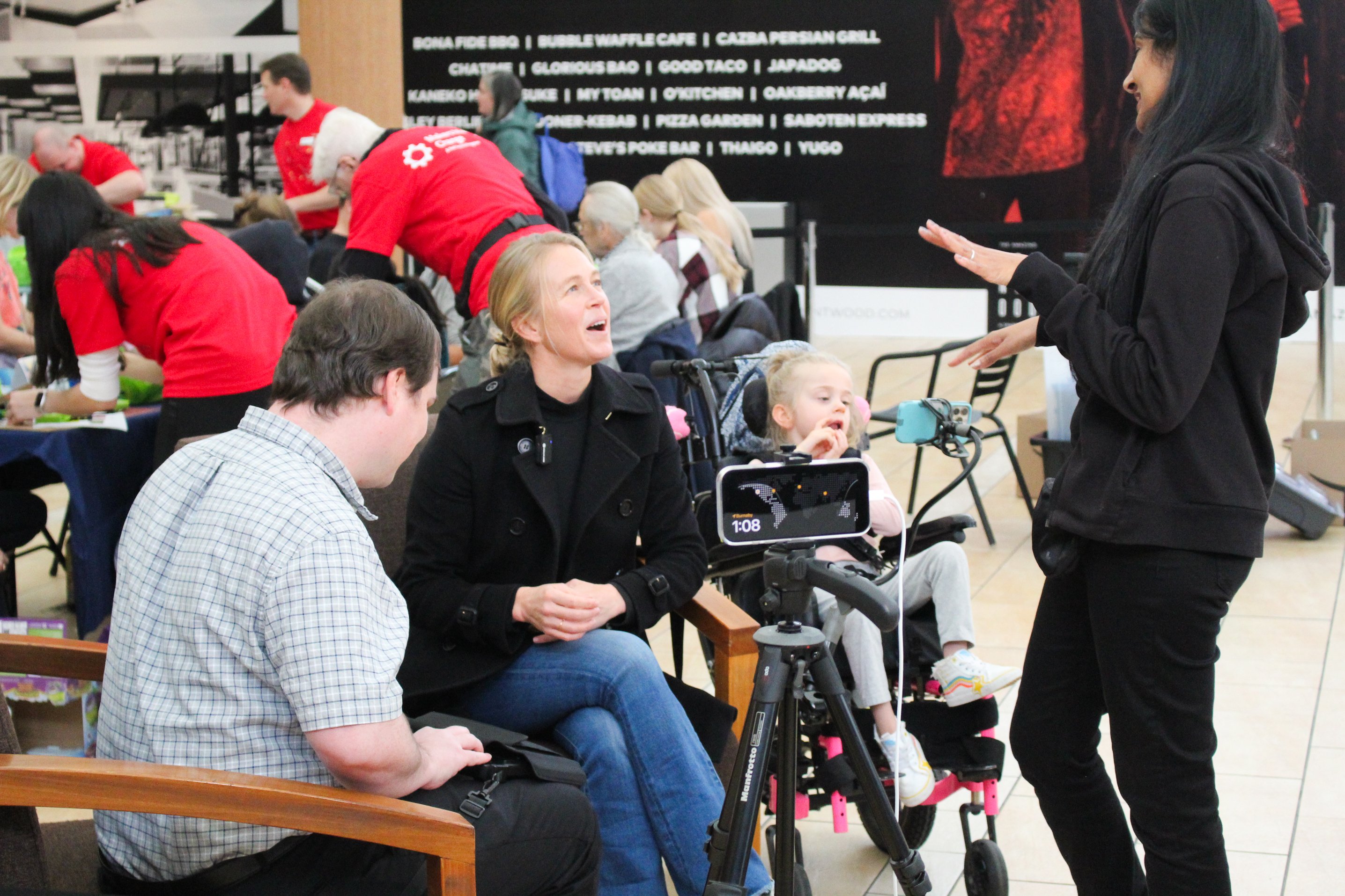 Carey and her daughter Evie, who received toys from Hacking for the Holidays, are interviewed by Grant Hardy on AMI.