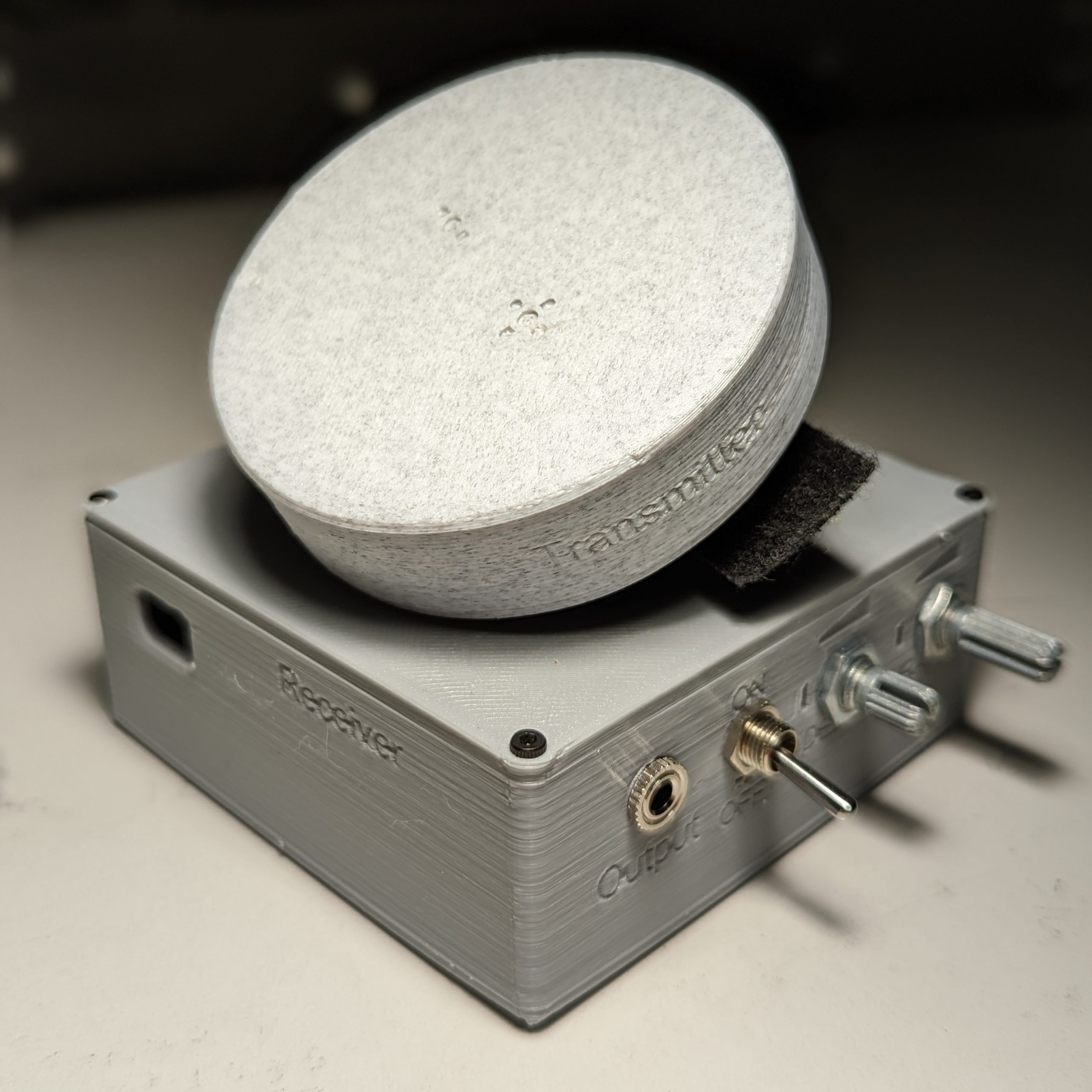 A grey 3d printed wearable clap switch and control unit.