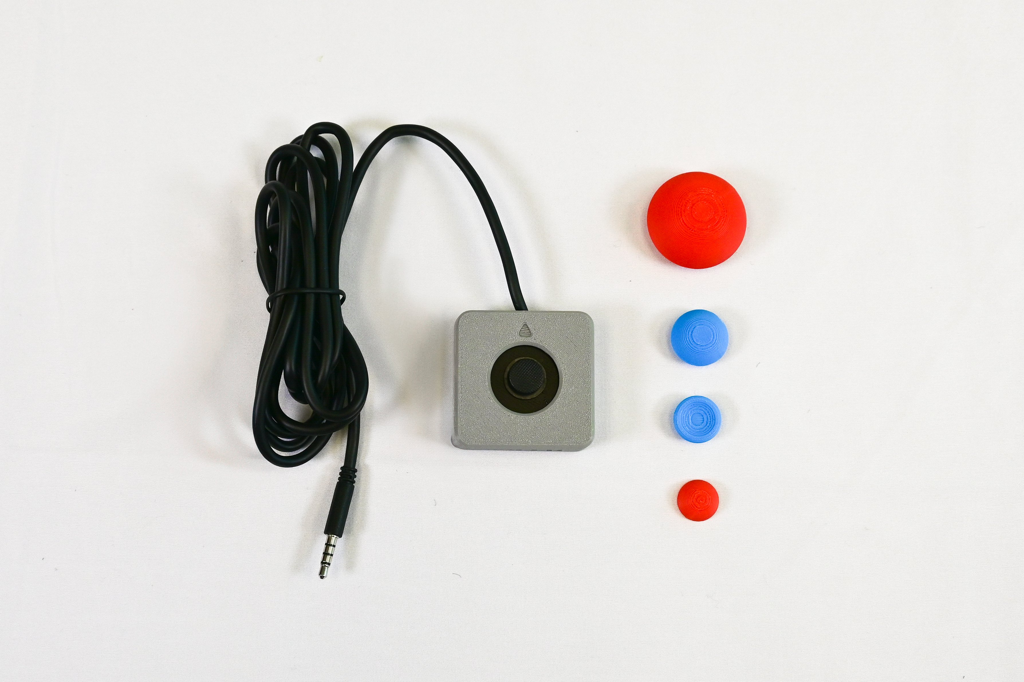 A grey joystick with multiple, colorful toppers