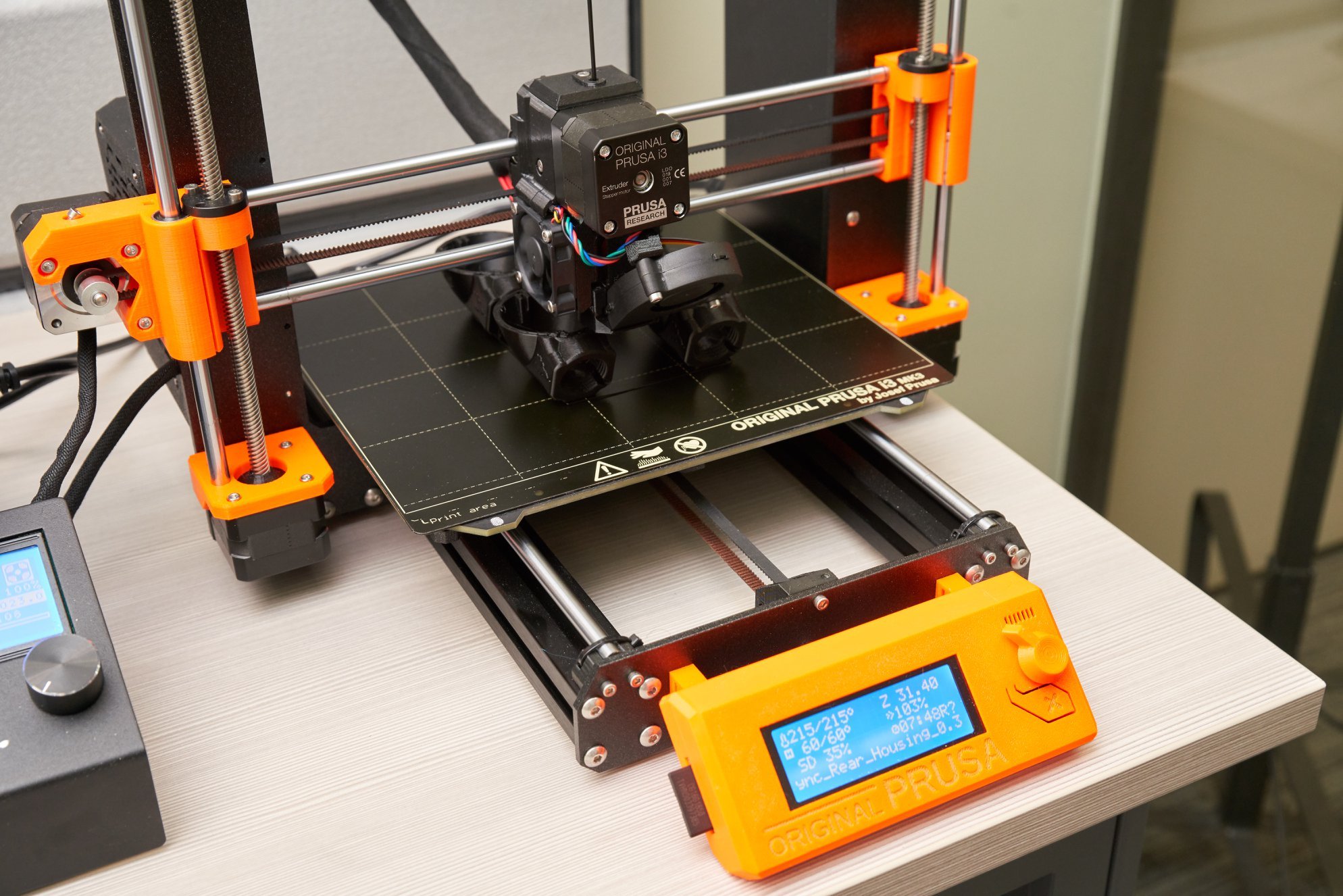 Closeup of a orange and black 3d printer