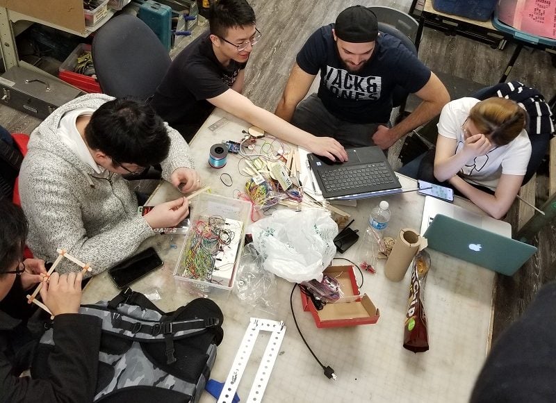 An overhead shot of five volunteers working on a design.