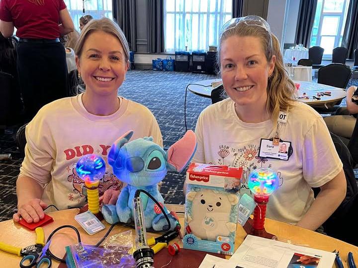 Two occupational therapists holding adapted toys
