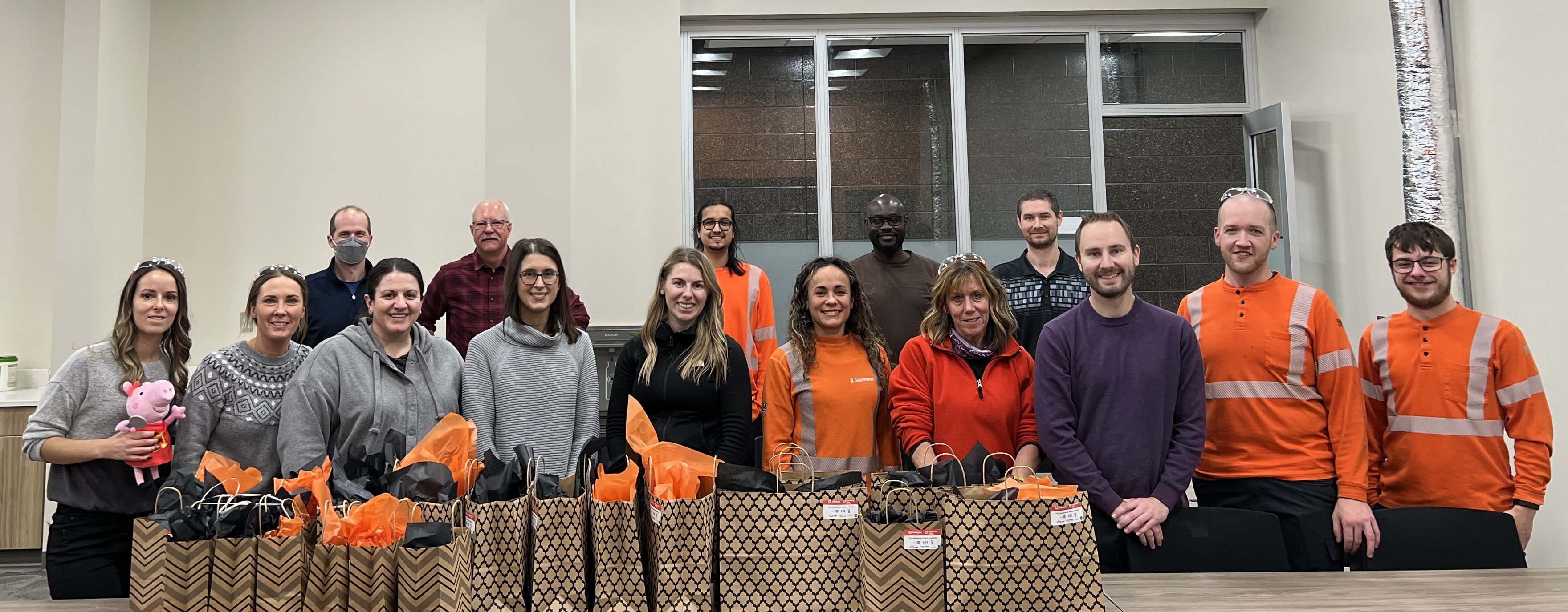 A group of SaskPower employees in front of bags of toys