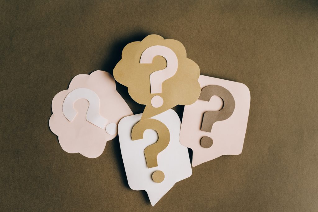 Question mark graphic featuring four paper thought bubbles with question marks inside.