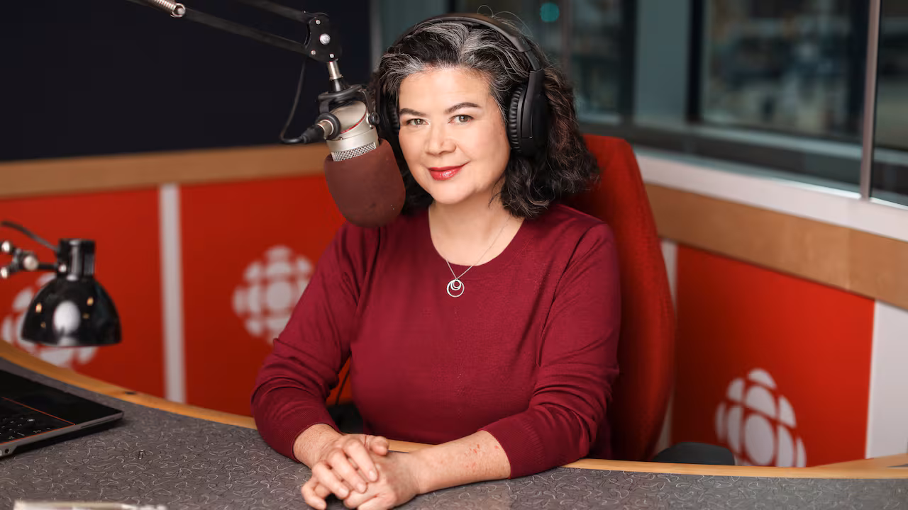 A woman with dark wavy hair in a recording studio