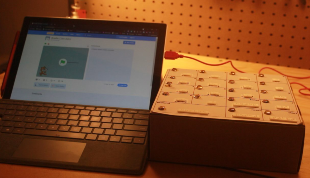 An assembled braille calculator connected to a laptop.