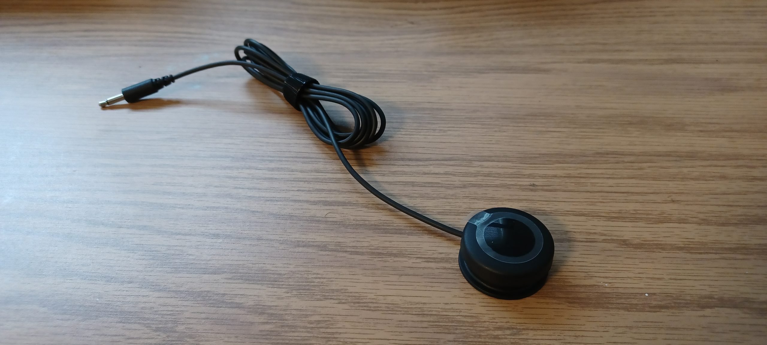 Logitech's light touch button against a wooden background.