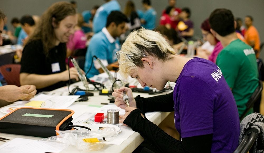 An EA participant soldering.