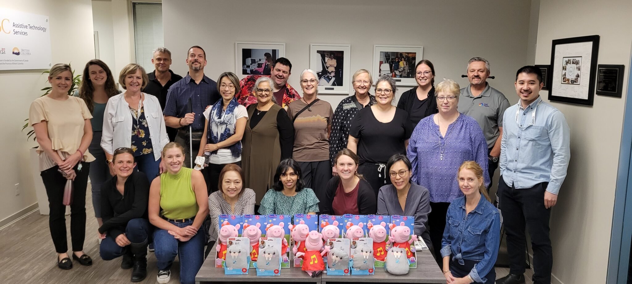 22 Neil Squire BC Solutions staff standing in the office lobby with adapted toys on the coffee table.