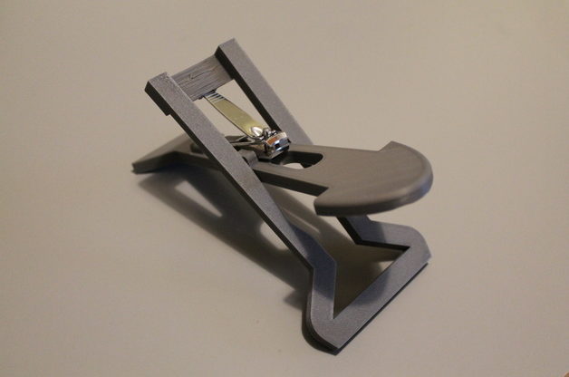 A grey 3d printed nail clipper on a white table