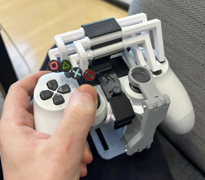 A hand holding a PS4 controller with 3d printed arm attached in the middle.