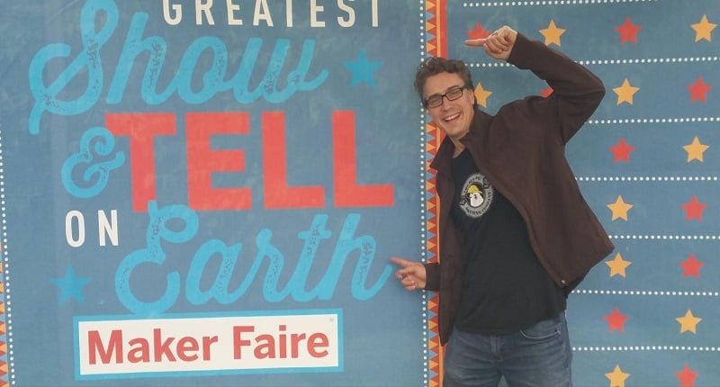 MMC's Director of Innovation Chad pointing toward a Maker Faire sign.