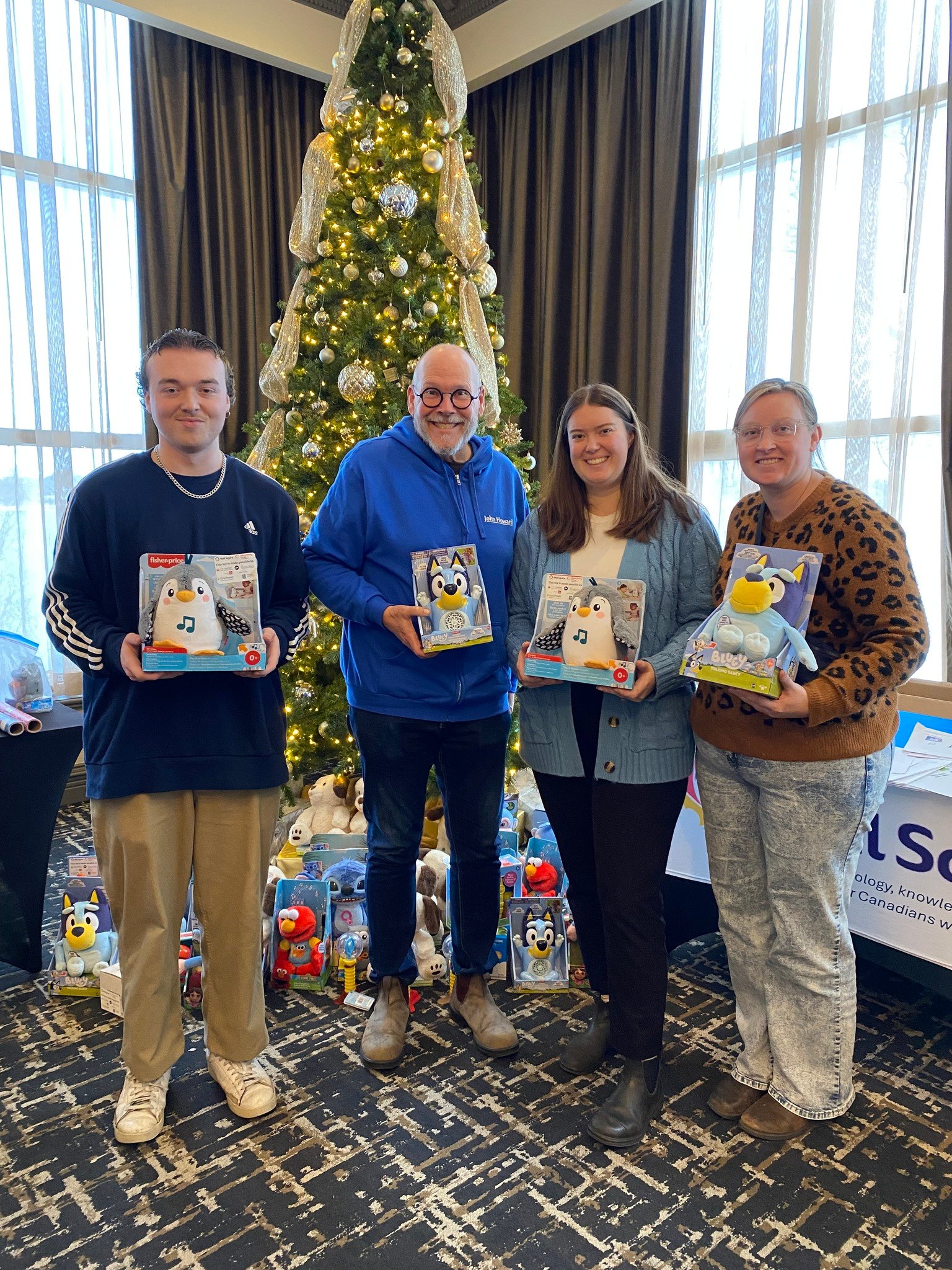4 volunteer makers holding an adapted toy penguin and Bluey