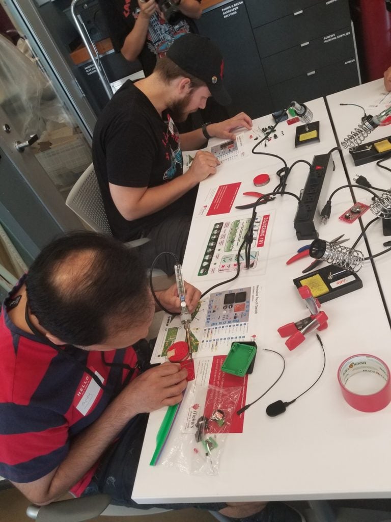 An image of two volunteers making assistive devices.