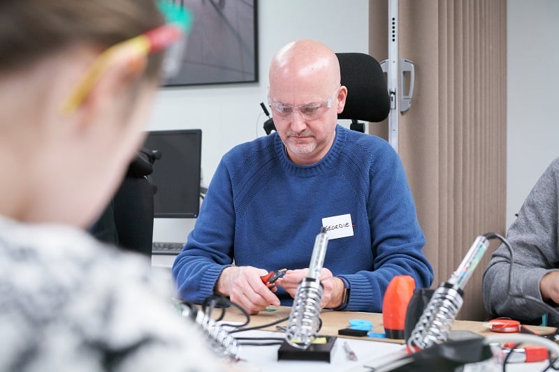 A participant using wire cutters at a build event.