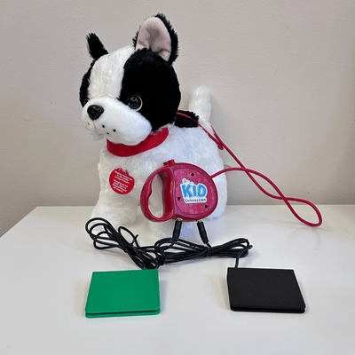 Black and white French bulldog plush toy with a red leash and two switches plugged into the leash.