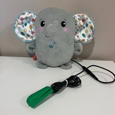 A light touch switch plugged into a plush toy shaped as an elephant with large ears