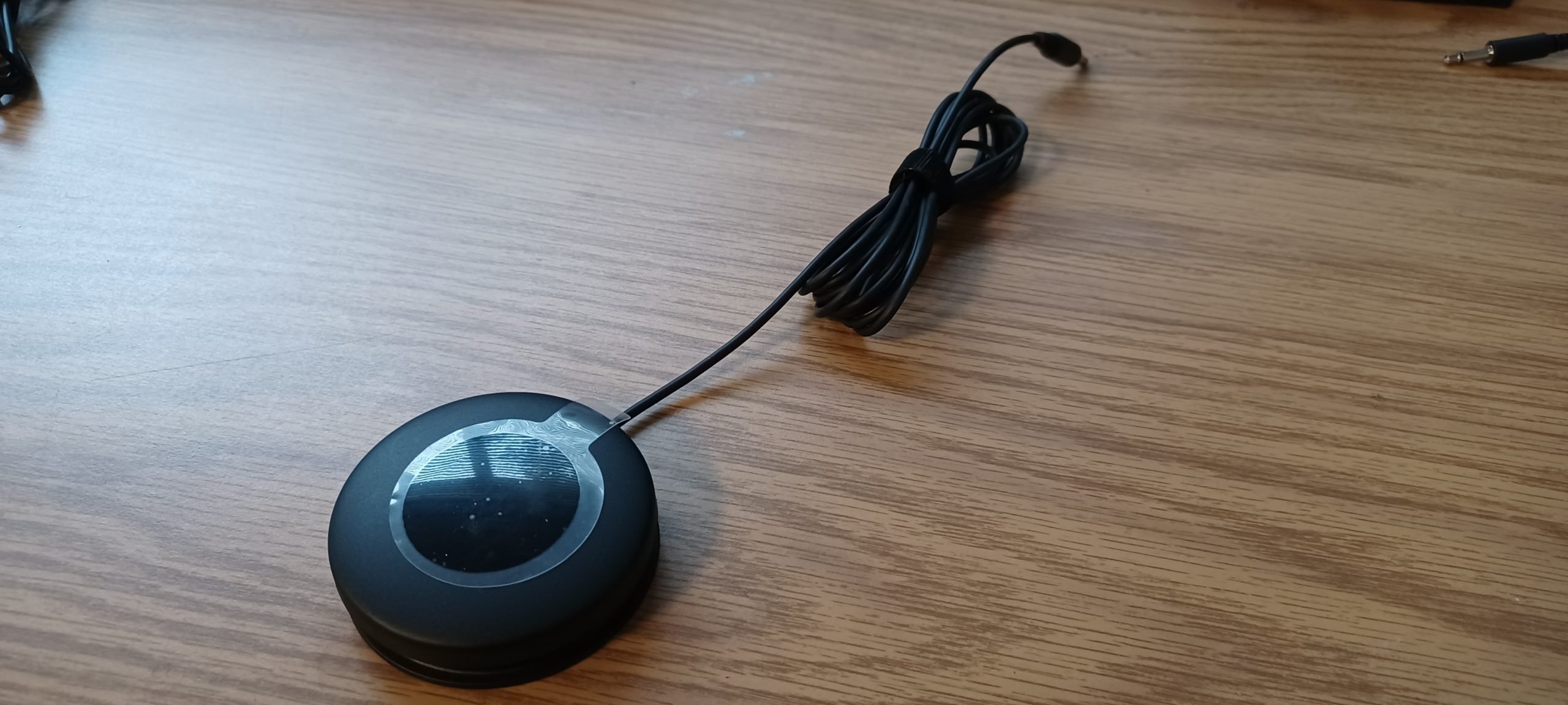Logitech's large button against a wooden background.