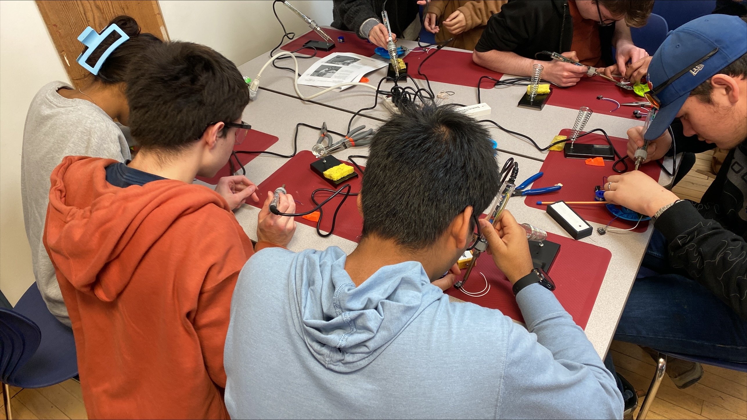 Students at a table adapting toy cars