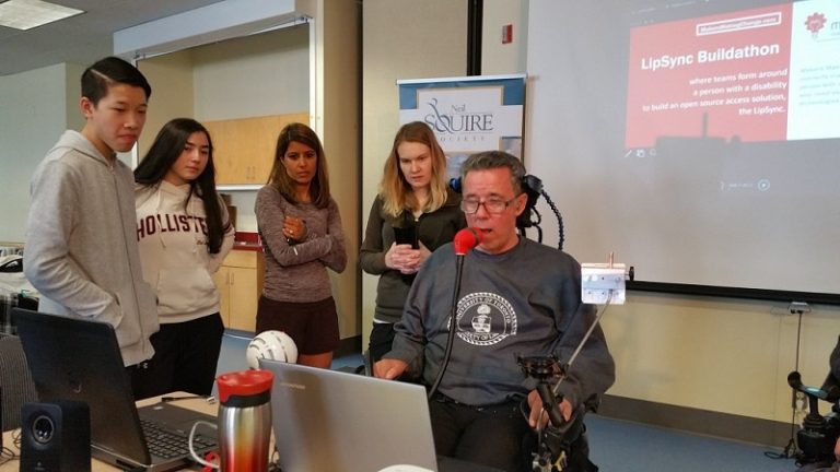 A user testing out the LipSync surrounded by students and staff.
