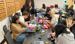 A group of students soldering adaptive devices.