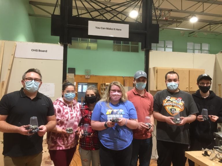 Volunteers holding assistive devices.