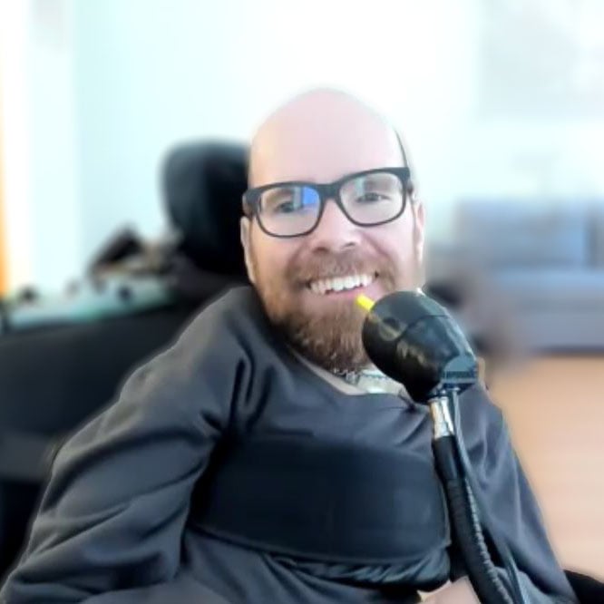 Ean in his wheelchair smiling with the new LipSync.