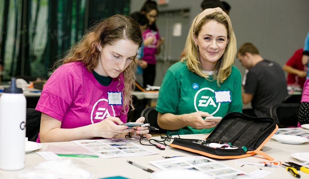 Two EA staff pictured looking through a soldering kit.