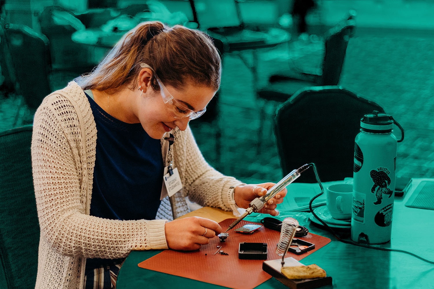 A woman soldering electronic components.