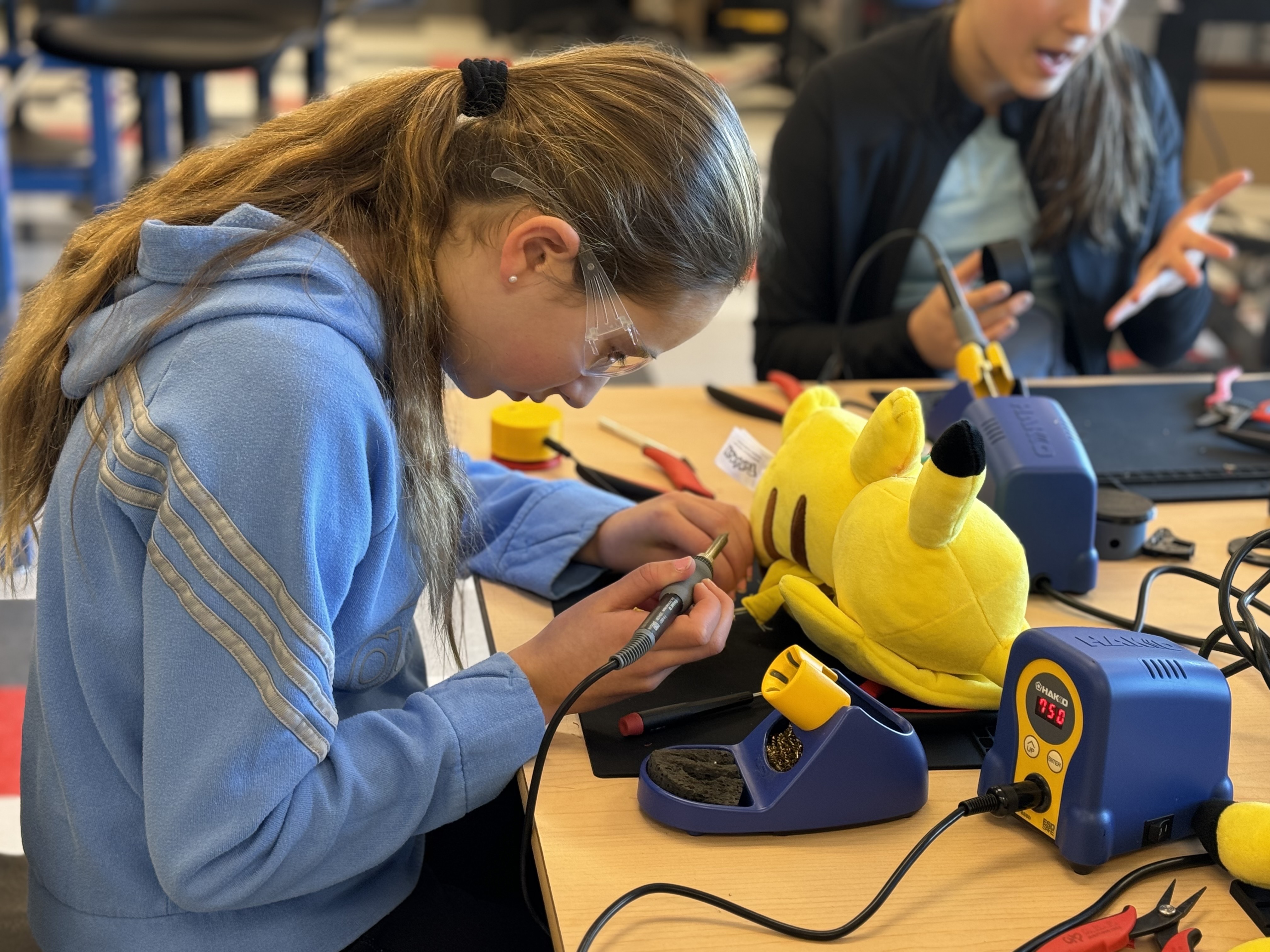 A student works on switch-adapting a Pikachu toy.