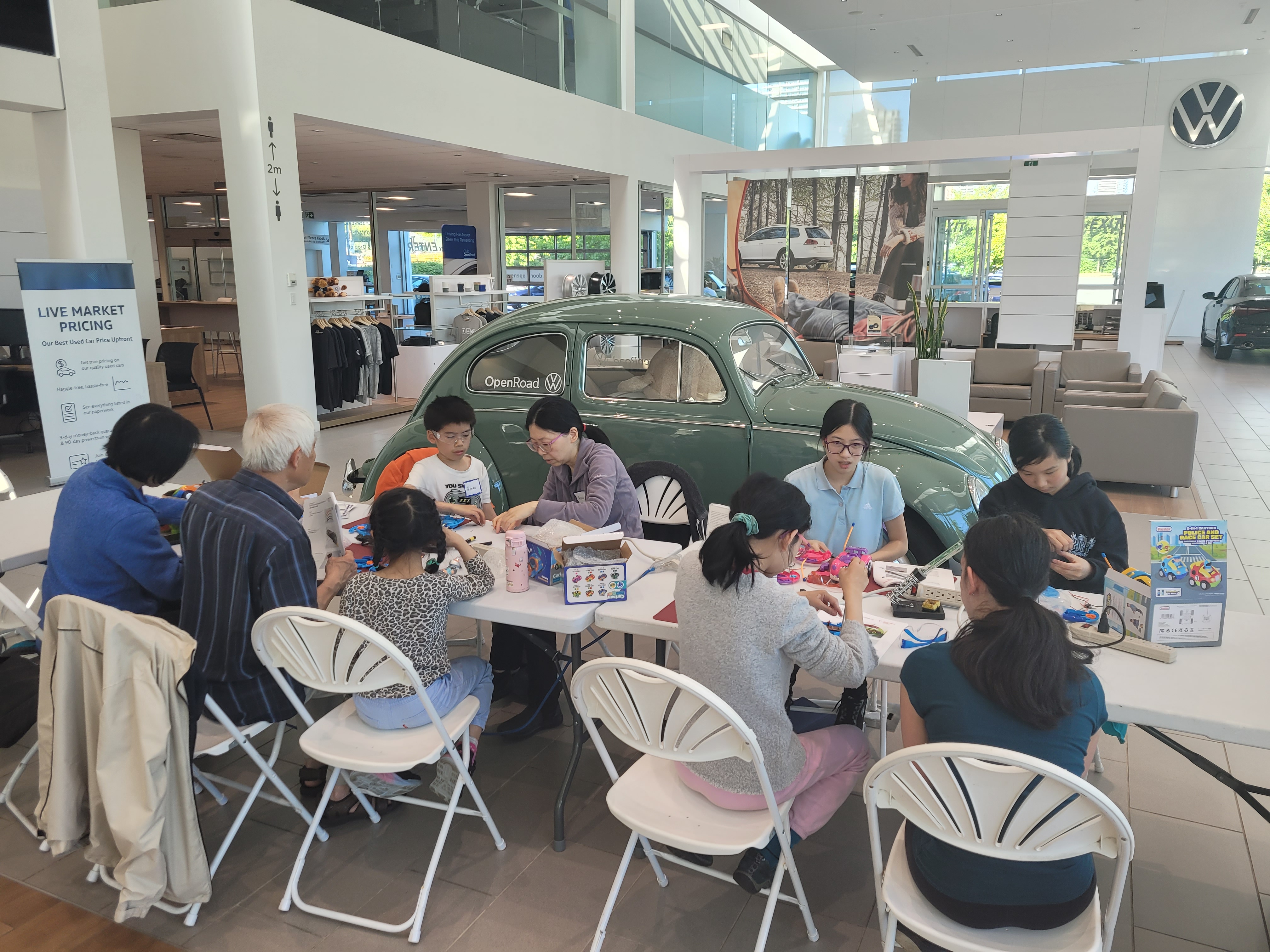 Youth volunteers and families at OpenRoad Volkswagen Burnaby work on adapting toys.