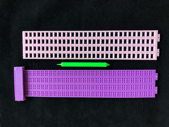 A pink and purple 4 line Braille Slate with a Green Stylus