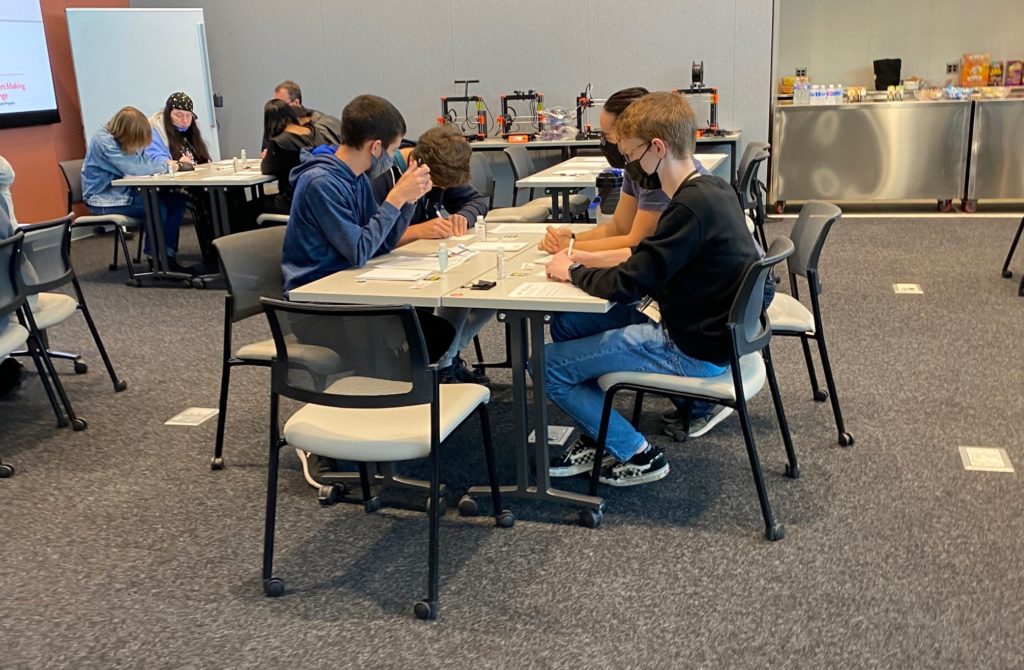 A table of volunteer makers building assistive technology.