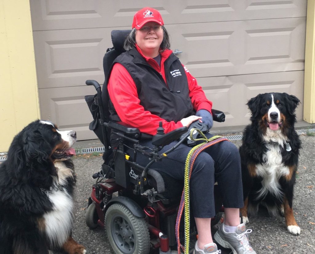 Michelle, an MMC volunteer, pictured alongside two dogs.