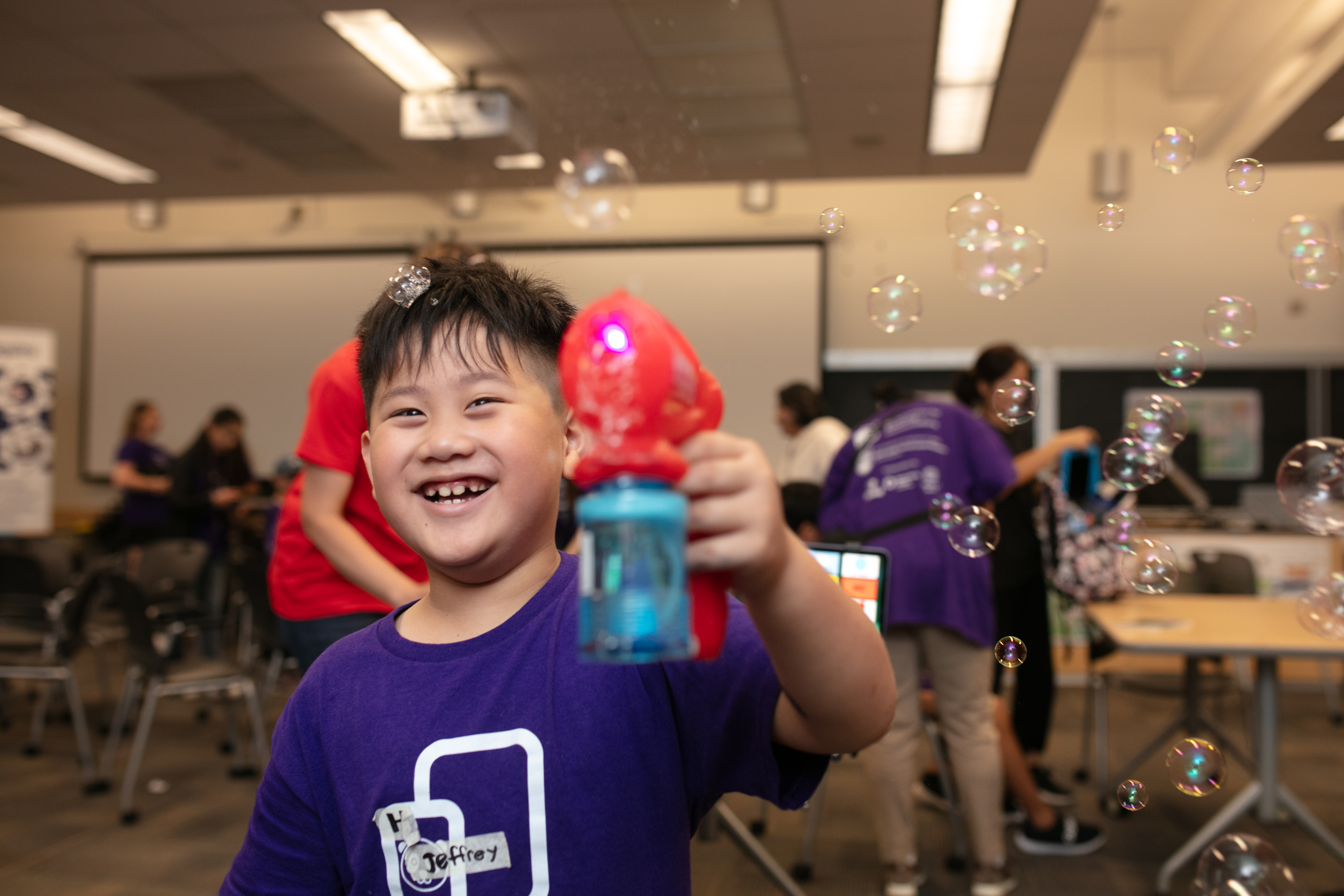 A child using a bubble blower.