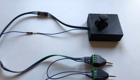 A black 3d printed joystick with two plugs.