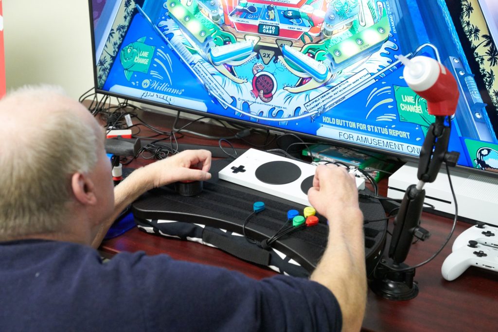 A person using the XBox adaptive controller to game.