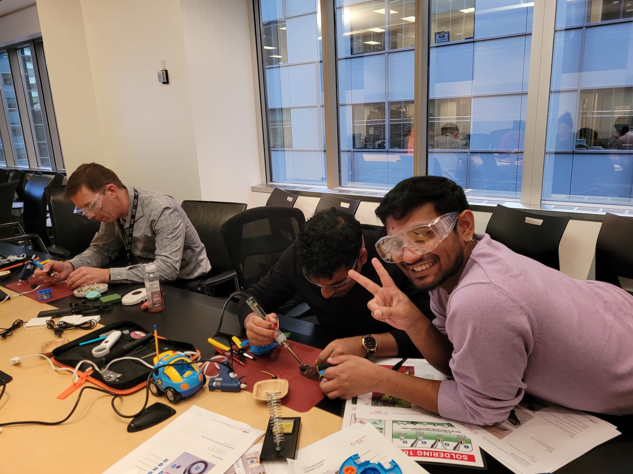 Three volunteers adapting a toy race car.