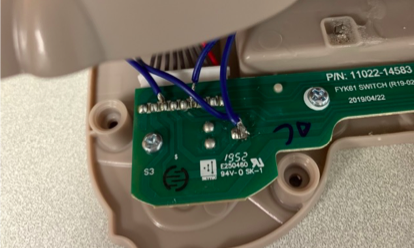Close up shot of a PCB board with blue wires attached.
