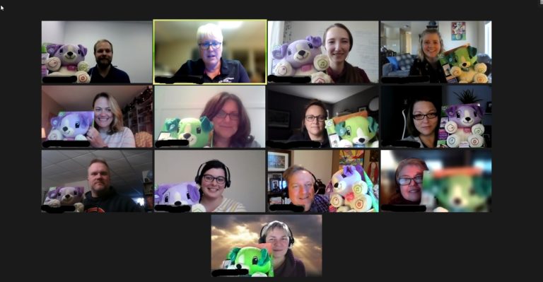 A screen capture of a build event with participants holding up their adapted toy.