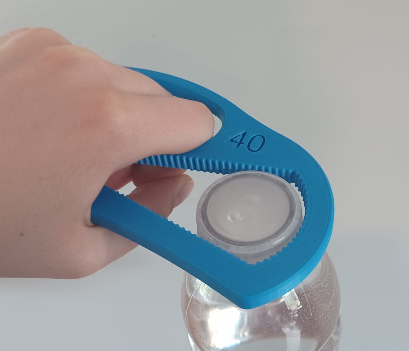 Hand opening bottle using assistive bottle opening device.