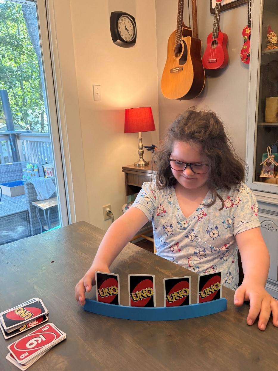 Mira using a Single Row Playing Card Holder to play Uno.