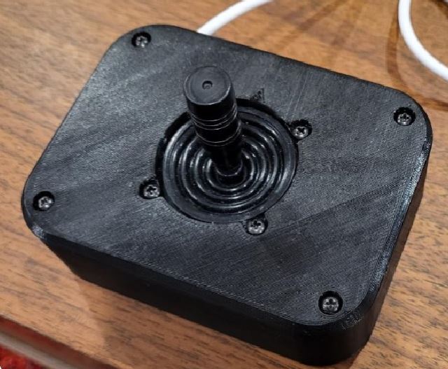A 3d printed black joystick on a table.