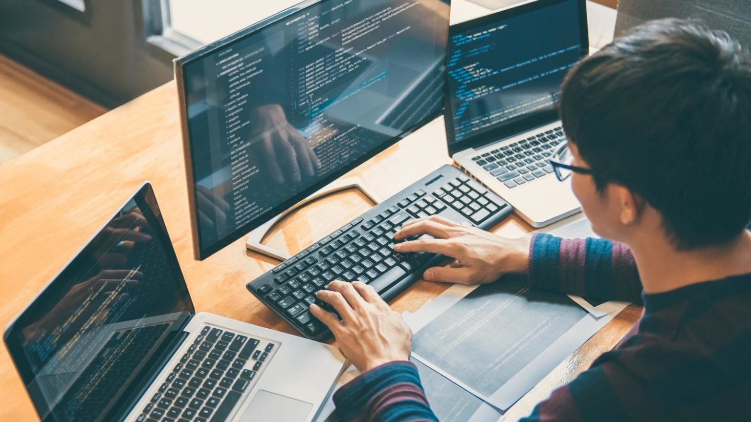 A person software coding on a computer.