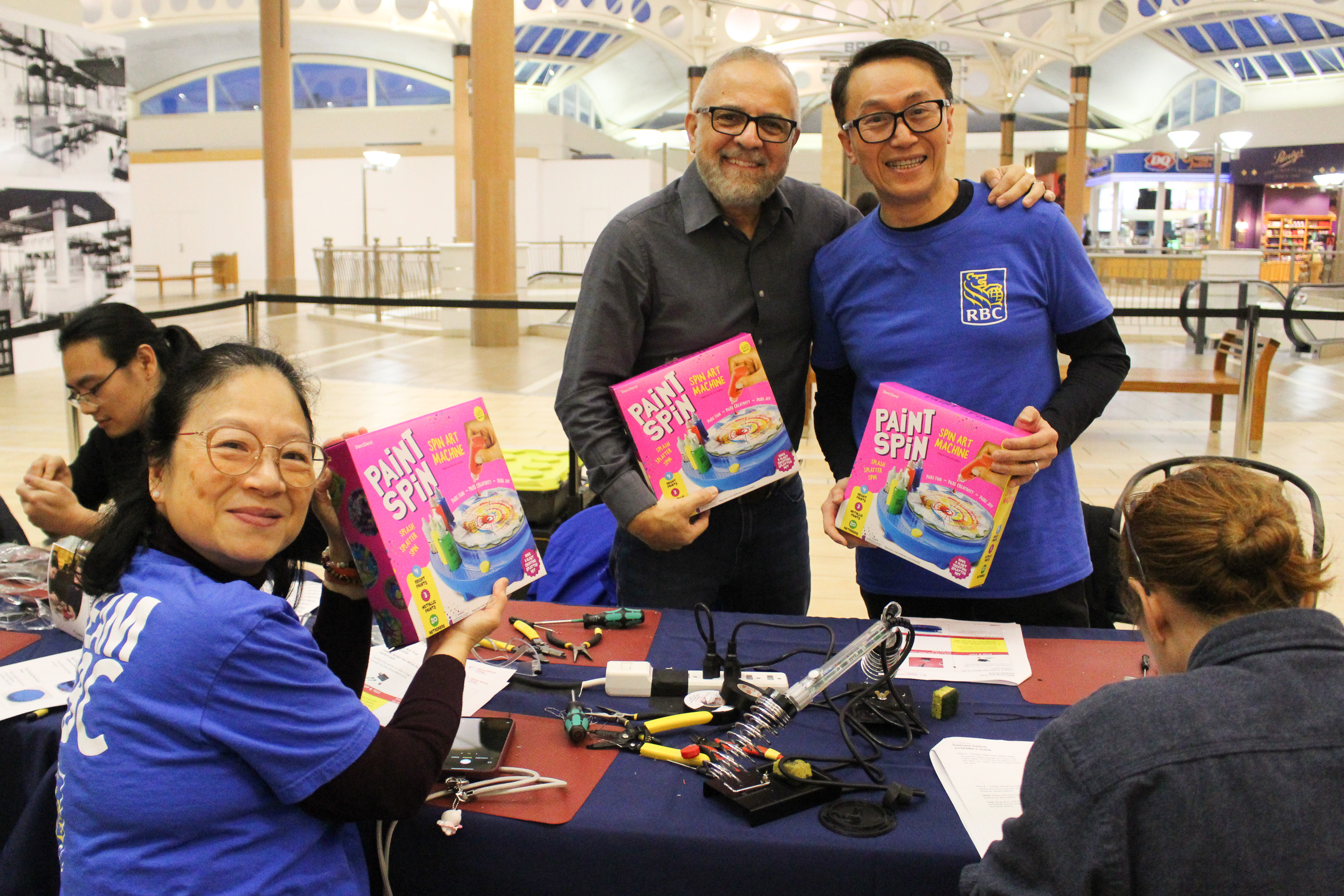 RBC employees show off the toys they are working on.